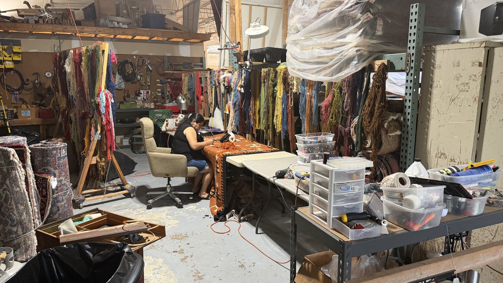 Rug repair bench with hand-dyed wool skeins sorted by color